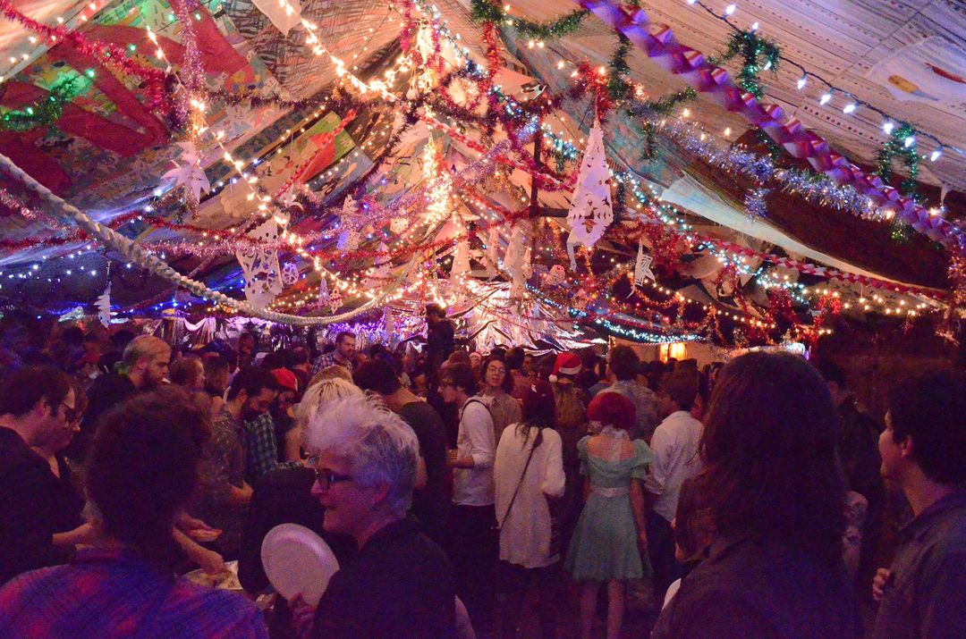 A large group of people under a tent with lights