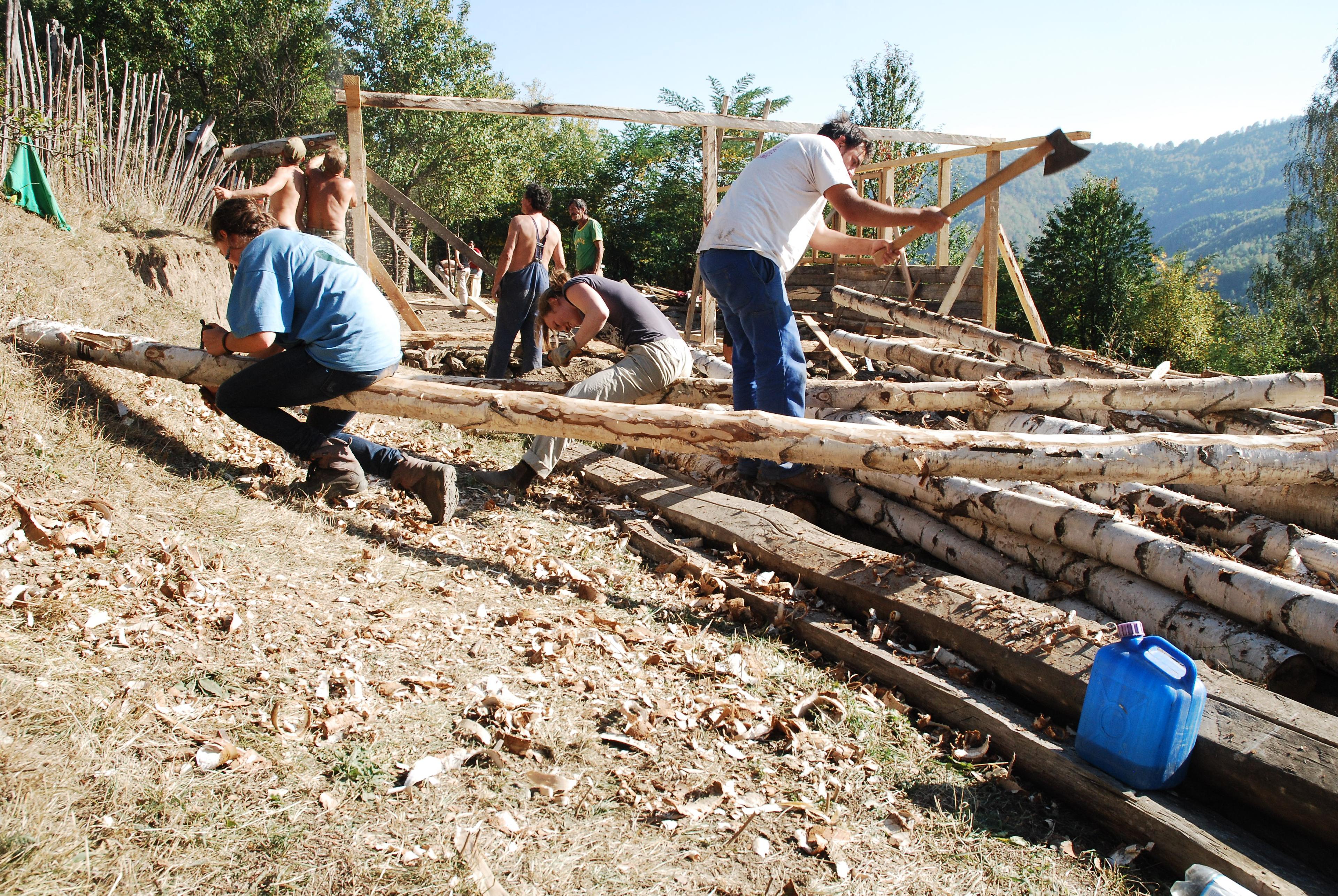 People working on building a wood house/structure