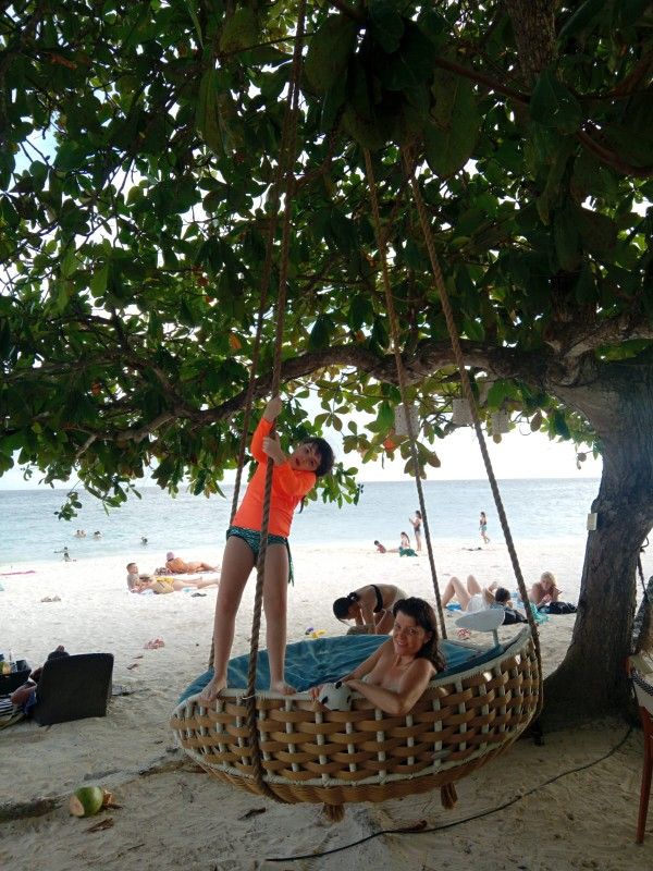 A woman posing on a balcony with a view of a lake