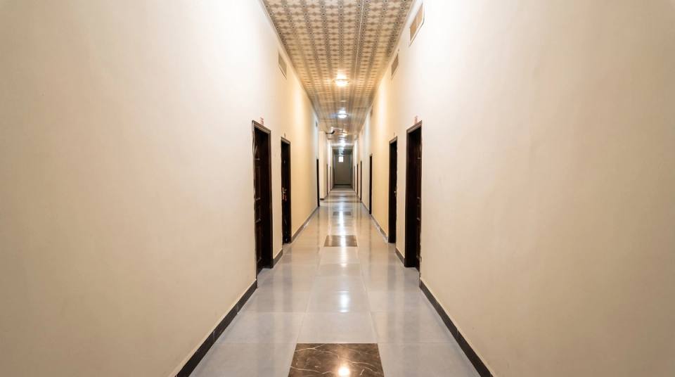 Corridor to the guest rooms with a tiled floor and patterned ceiling.