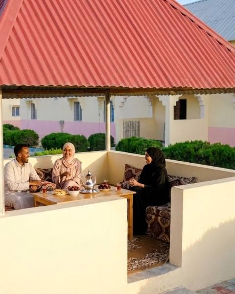A family shares tea in the garden pavilion.