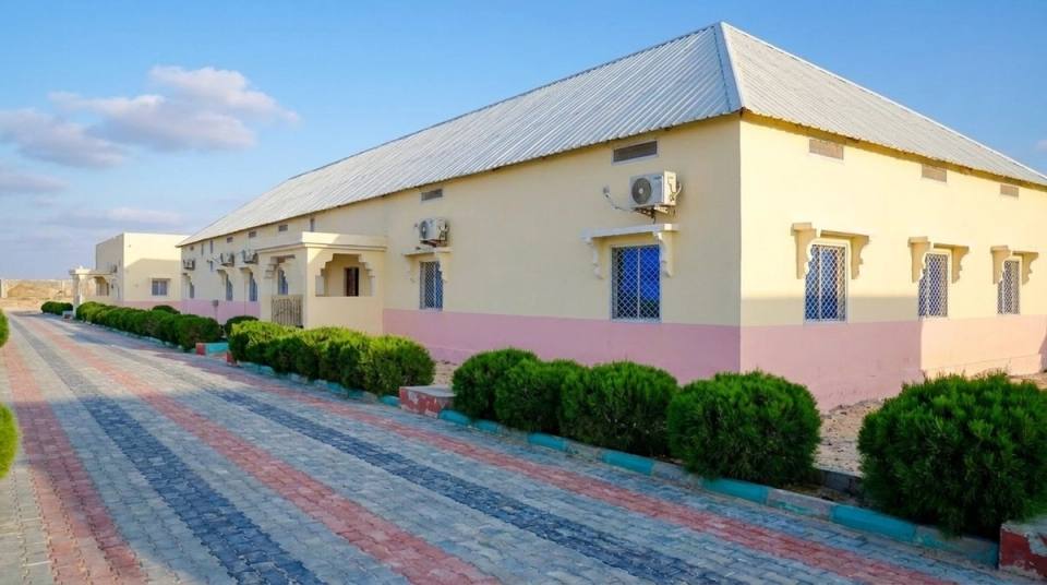 Iftin Hotel guest-room building with its paved path and trimmed shrubs.