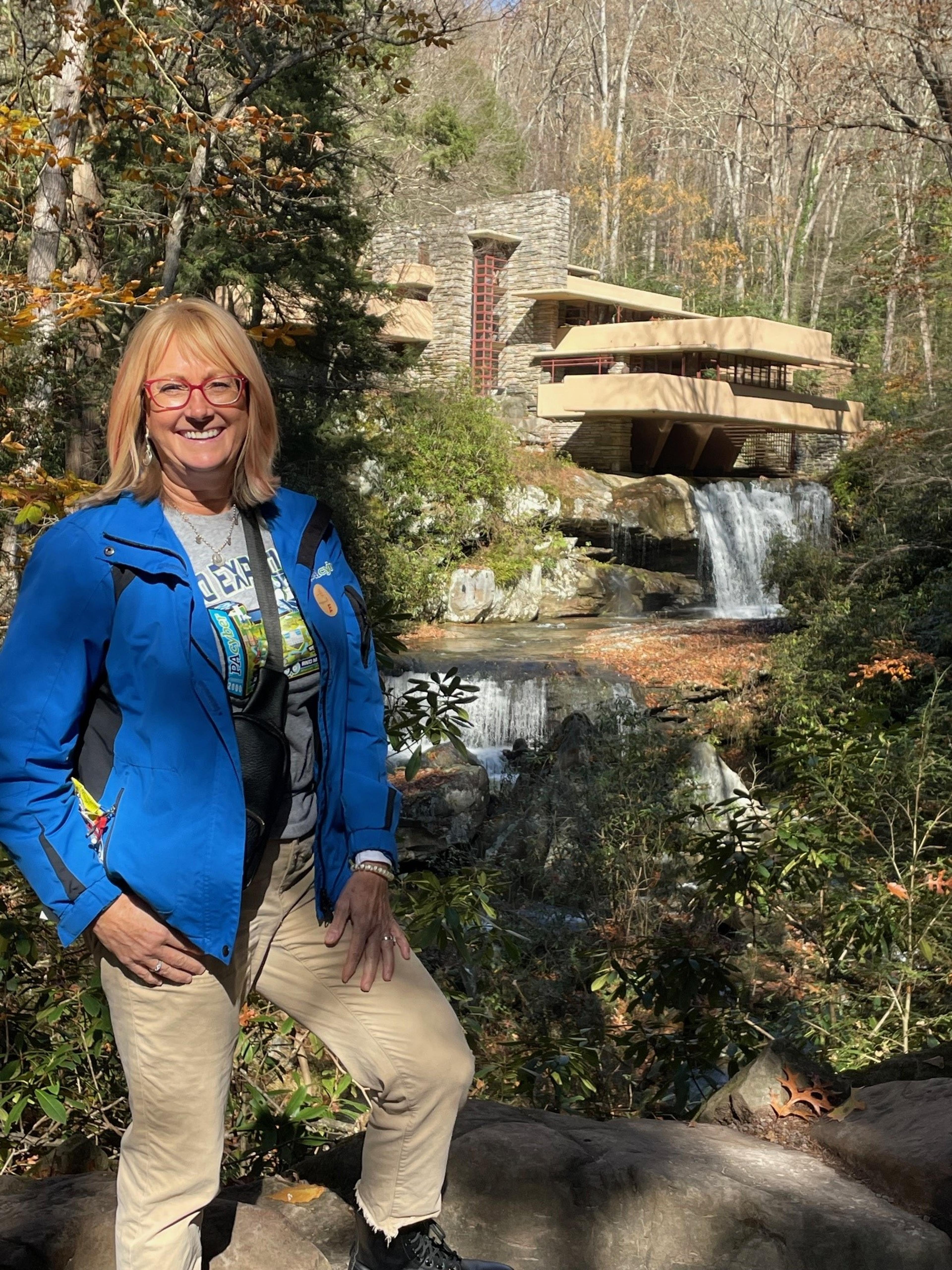 Jane is wearing a blue jacket and Wright's Fallingwater is in the background.