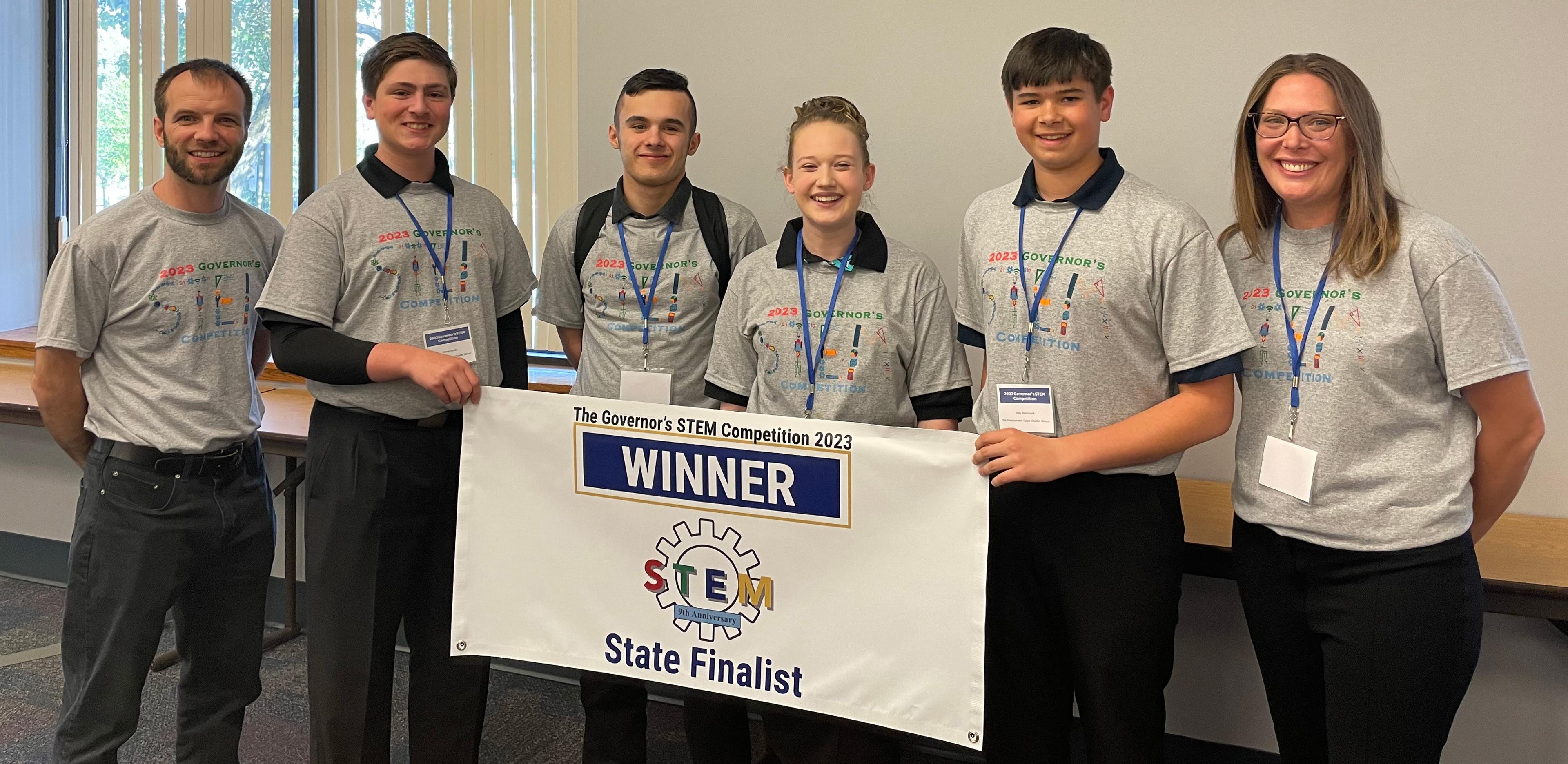 The winning PA Cyber team poses together around a sign that says "Winner."