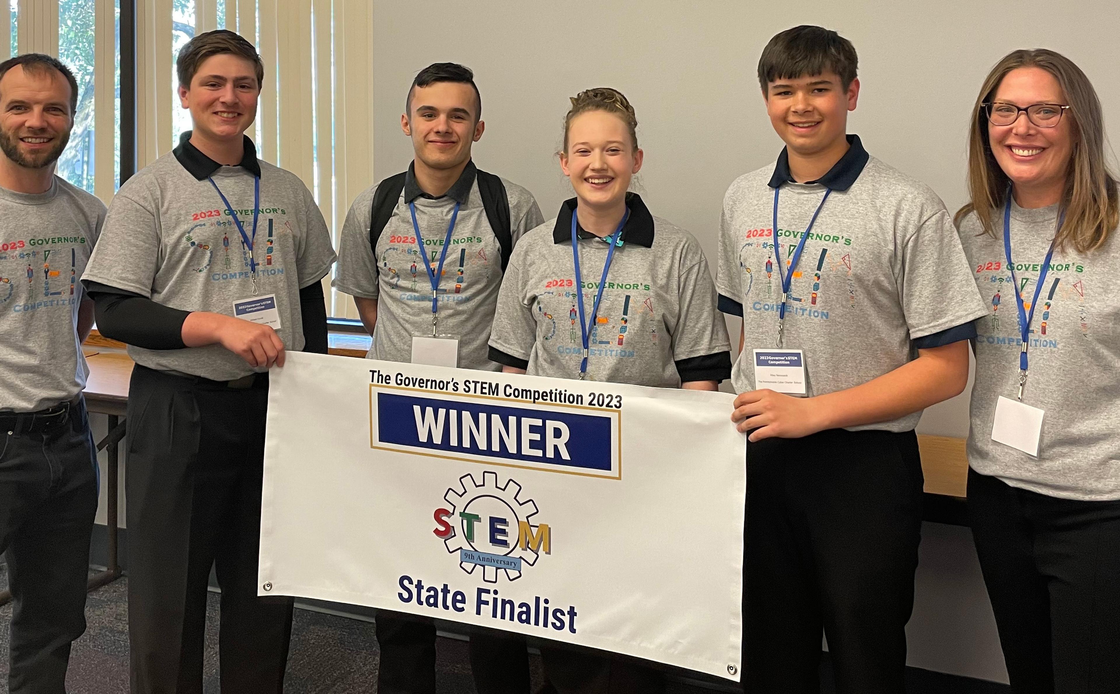 The winning PA Cyber team poses together around a sign that says "Winner."