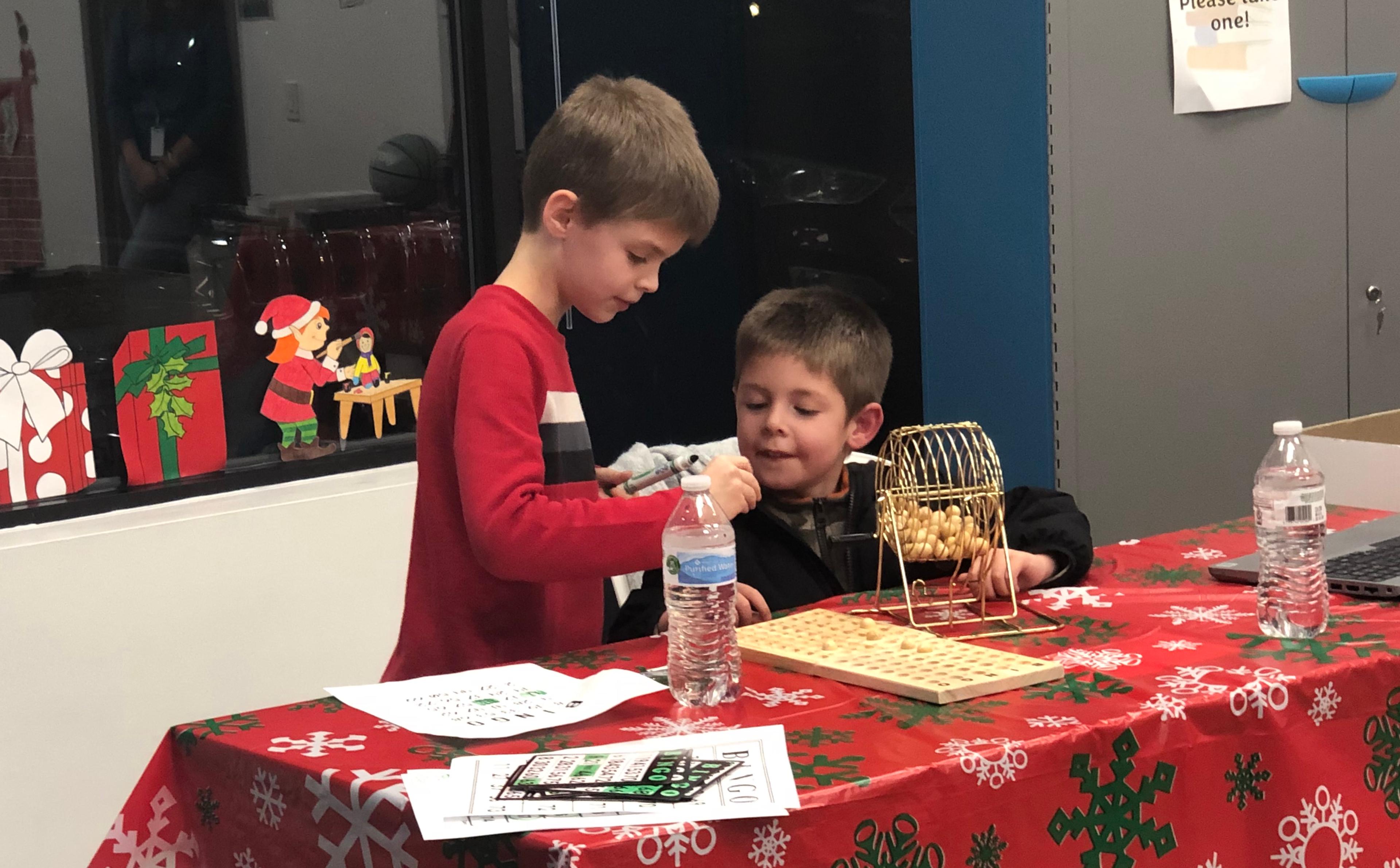 Two students read Bingo numbers at a PA Cyber holiday event.