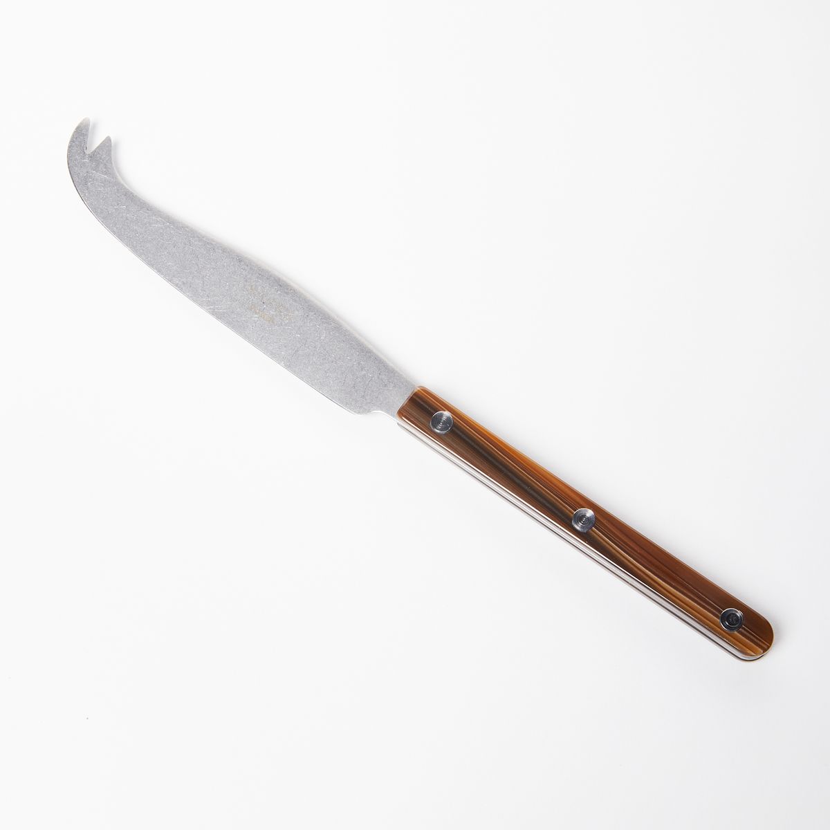 A stylish long and thin cheese knife with a brown acrylic handle and a scooped tip