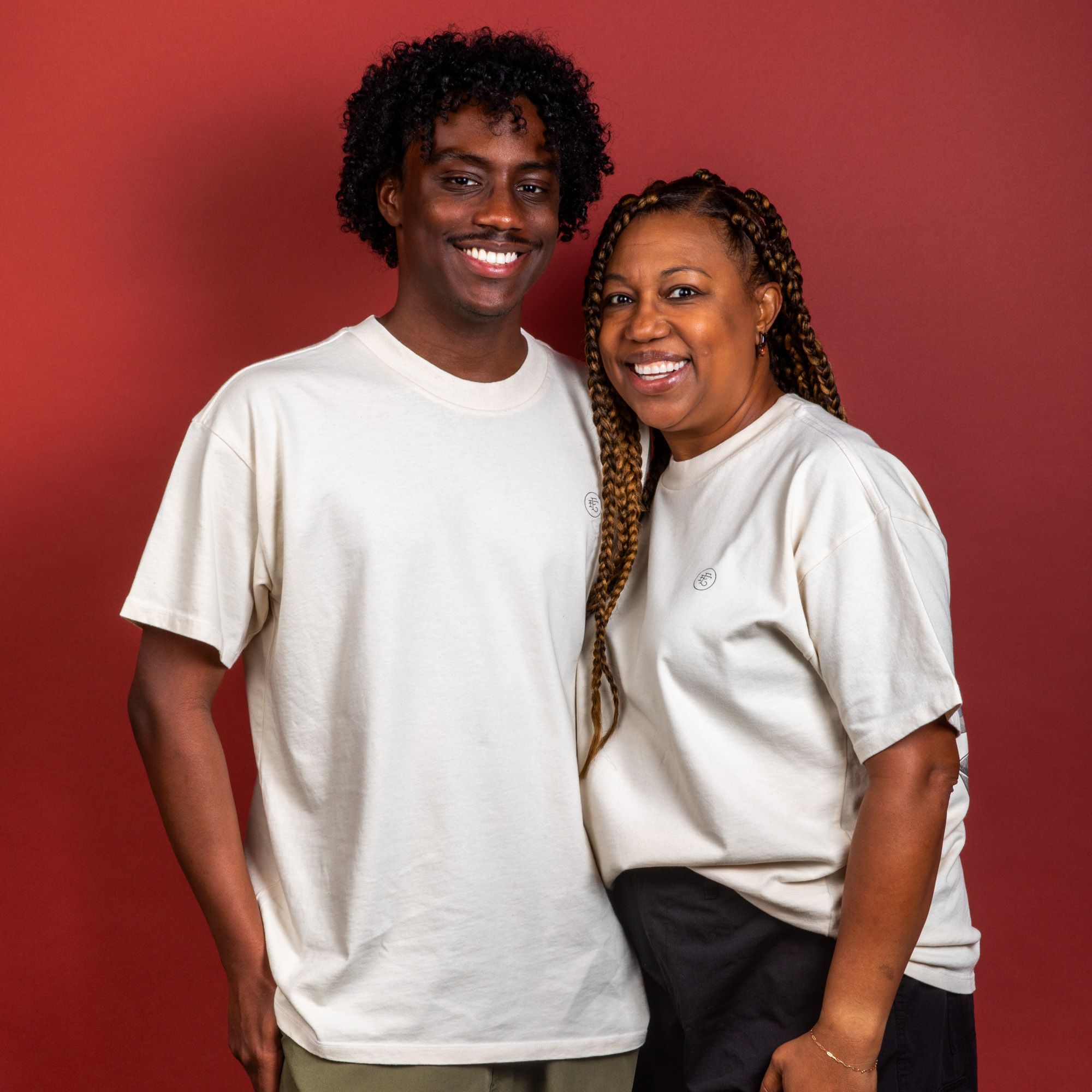 Two models wearing the t-shirt shown from the front smiling at the camera