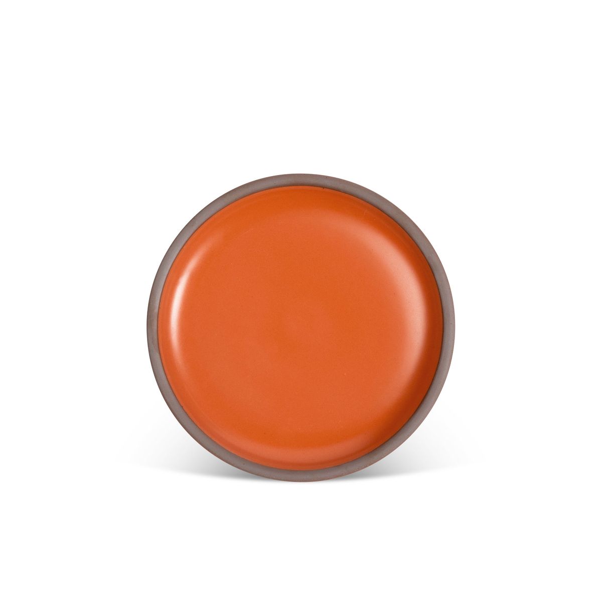 A medium sized ceramic plate in a bold orange color featuring iron speckles and an unglazed rim.