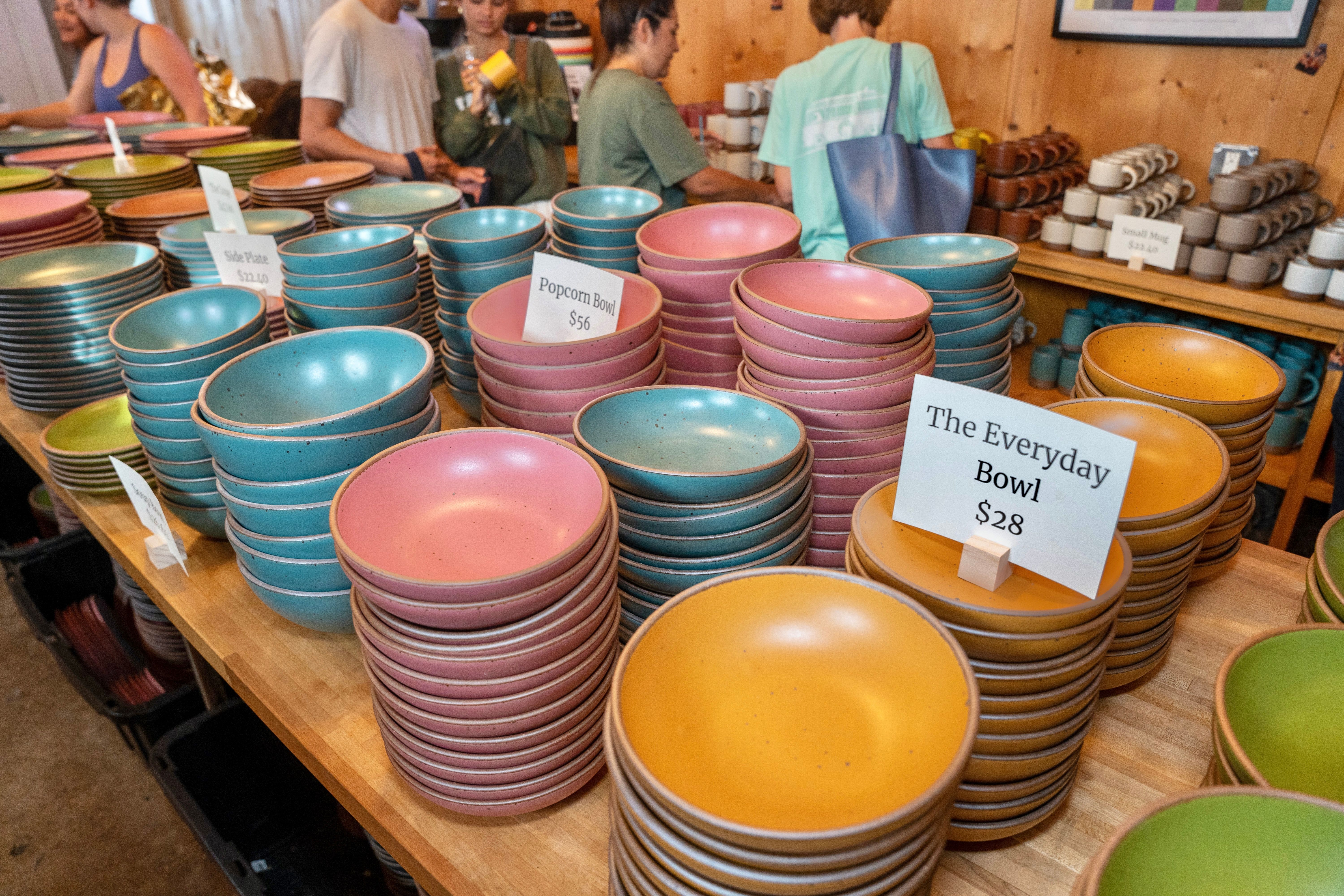 Stacks of colorful bowls in East Fork's punchy seasonal glazes set up at a Seconds Sale at Counter Culture Coffee in Charleston, NC