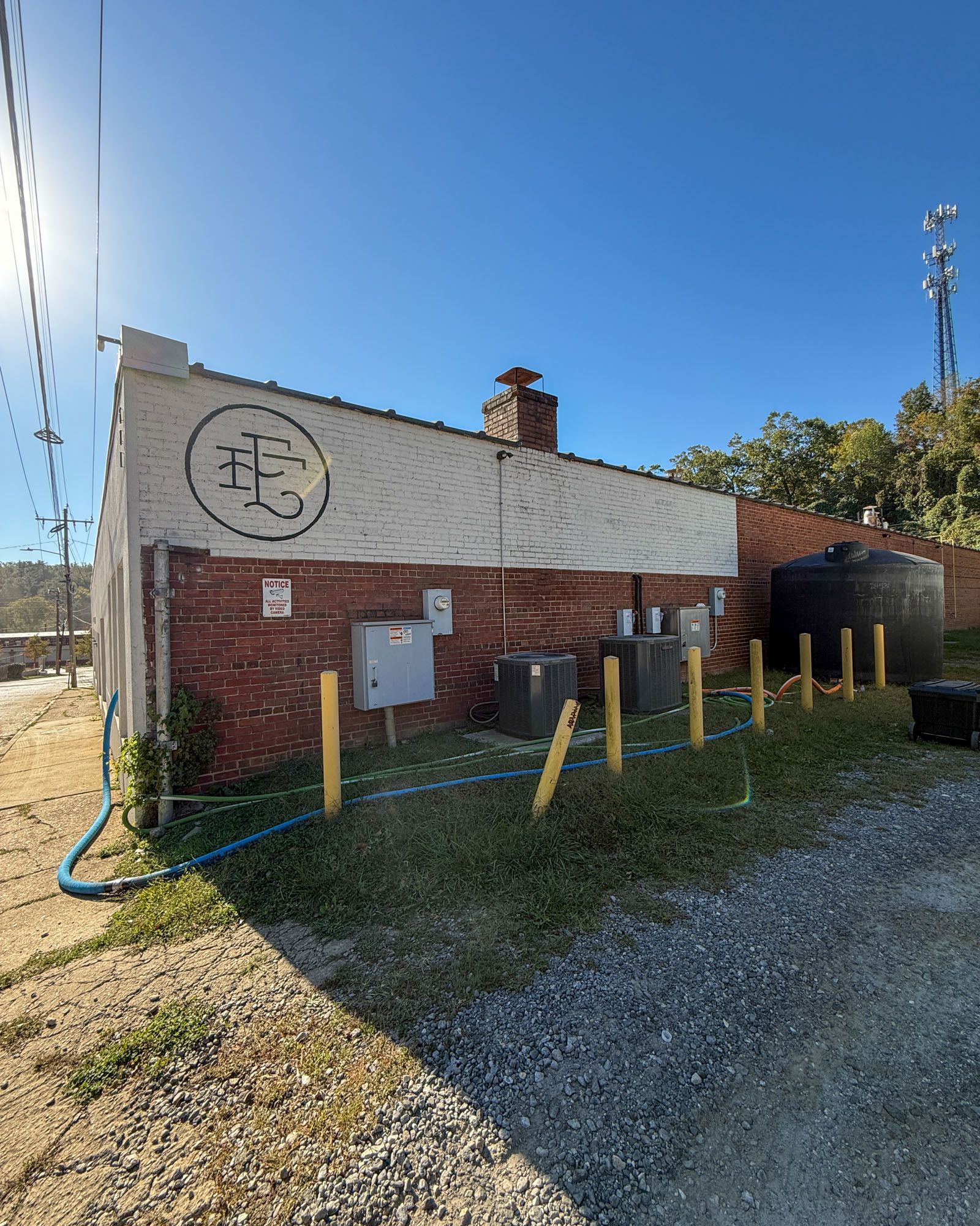 Outside of one of the East Fork buildings, is a large black water tank with a hose wrapping around and going into the building.