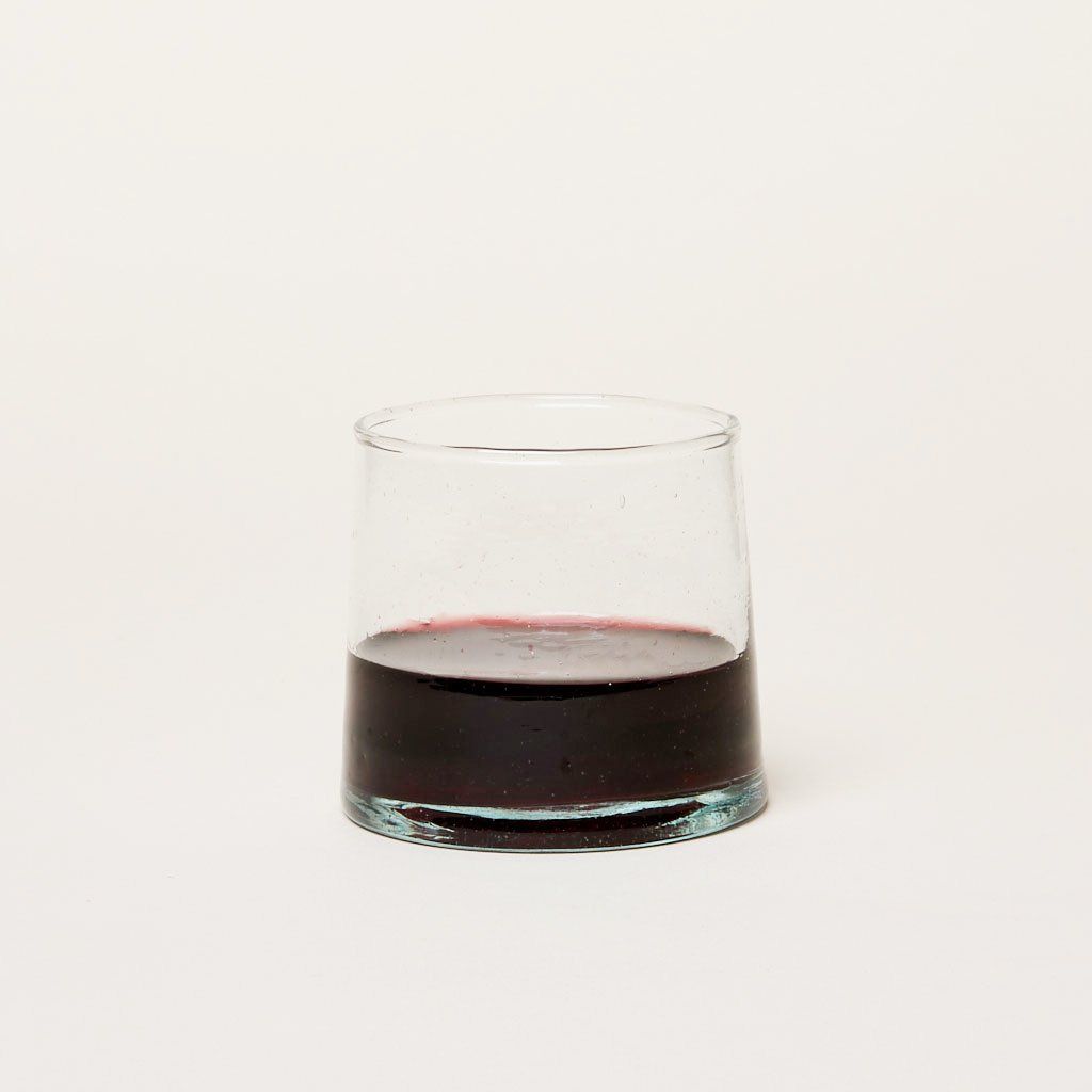 Short recycled Moroccan glassware glass half-filled with red wine