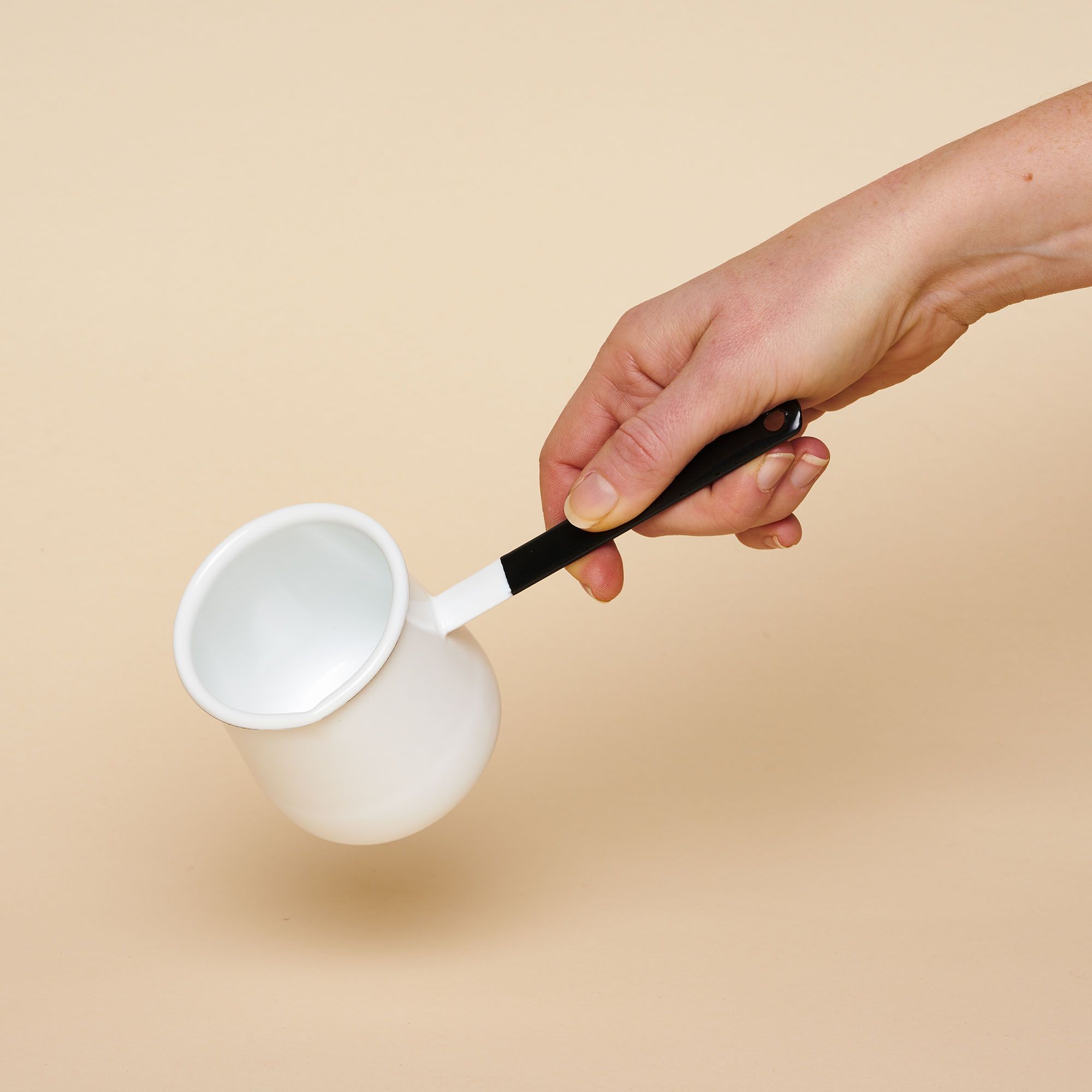 A small enamel pot that could fit in the palm of your hand