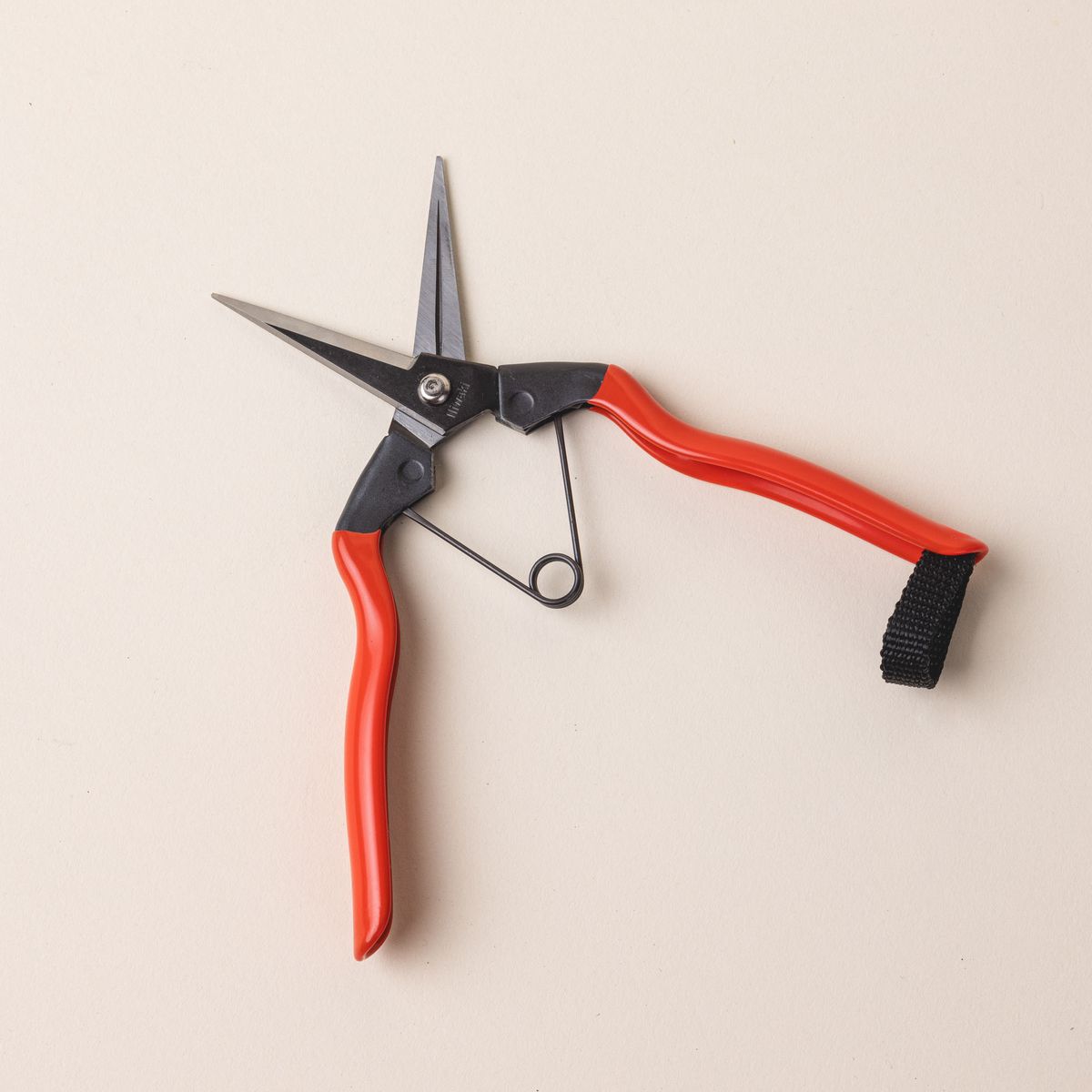 A pair of garden snips with an orange handle and narrow short blades