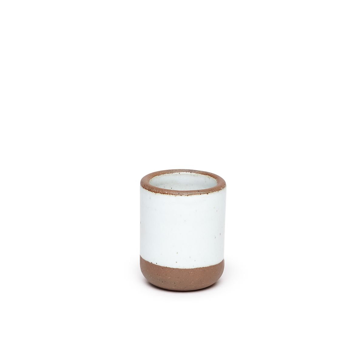 A small, short ceramic mug cup in a cool white color featuring iron speckles and unglazed rim and bottom base.