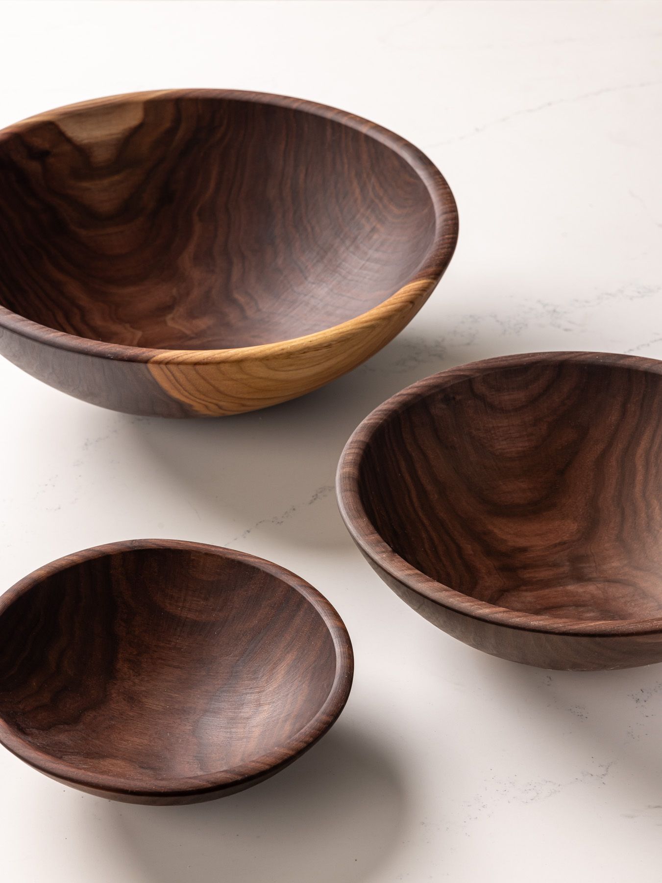 3 round walnut bowls in small, medium, and large sizes.