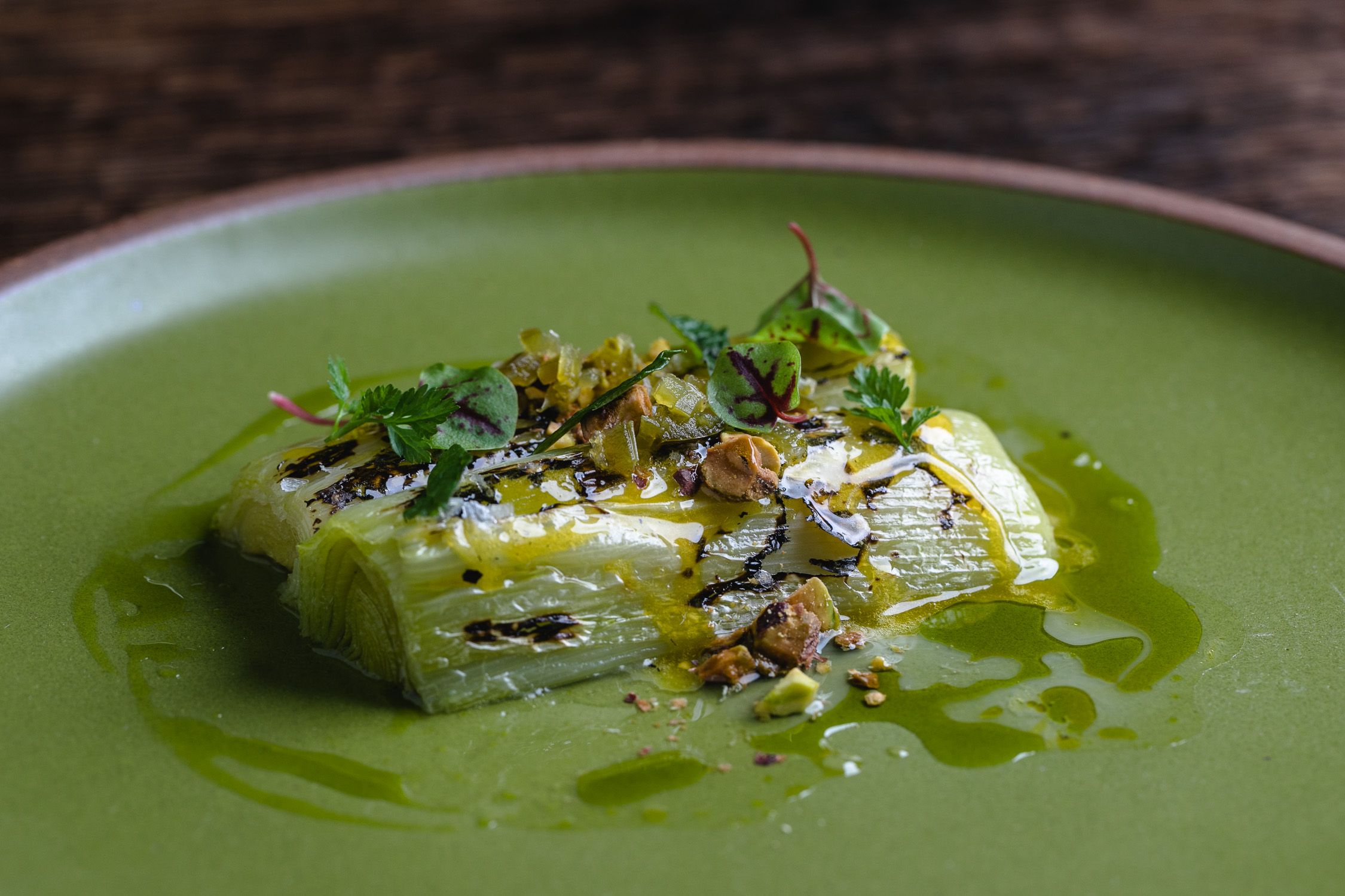 Leeks prepared and plated on an East Fork side plate in Fiddlehead color. 