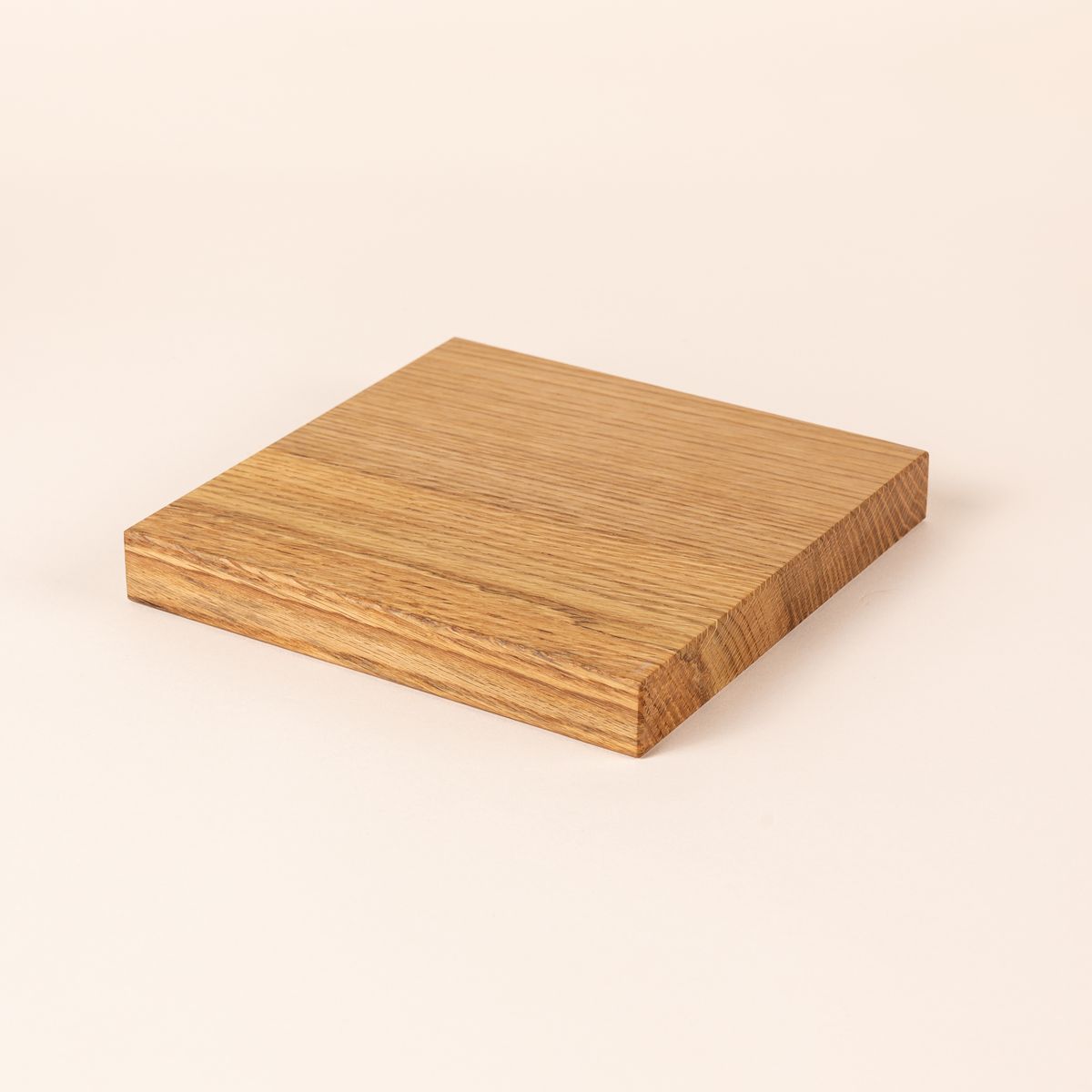 A thick rectangular cutting board made of light-colored wood