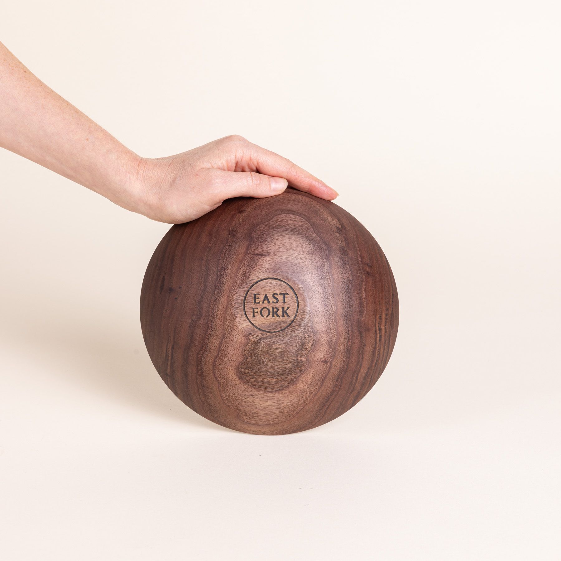 The bottom of a small walnut wood bowl with a stamp that reads "East Fork"