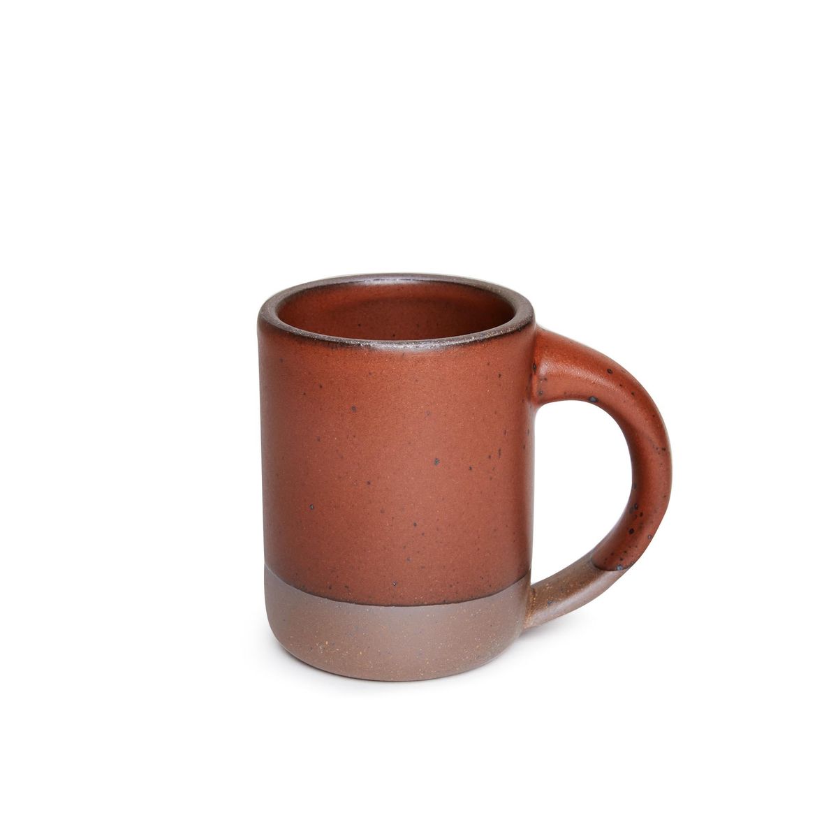 A medium sized ceramic mug with handle in a cool burnt terracotta color featuring iron speckles and unglazed rim and bottom base.