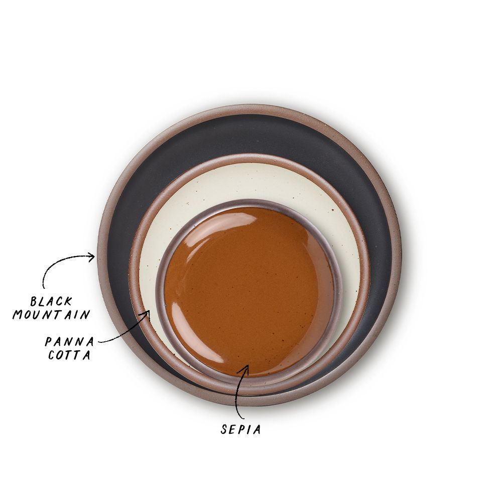 A stack of 3 plates in Dinner, Side, and Cake sizes in a black graphite, warm off-white, and glossy caramel brown colors.