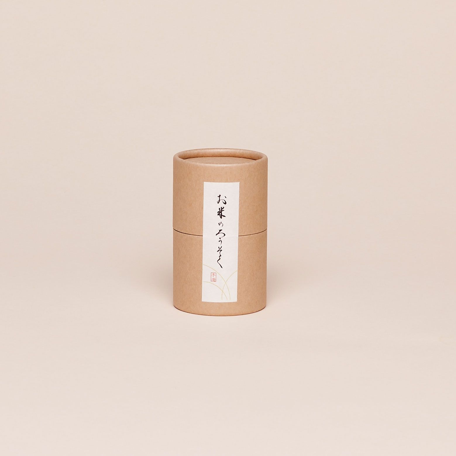 Brown paper cylinder with a vertical white label that has Japanese writing on it