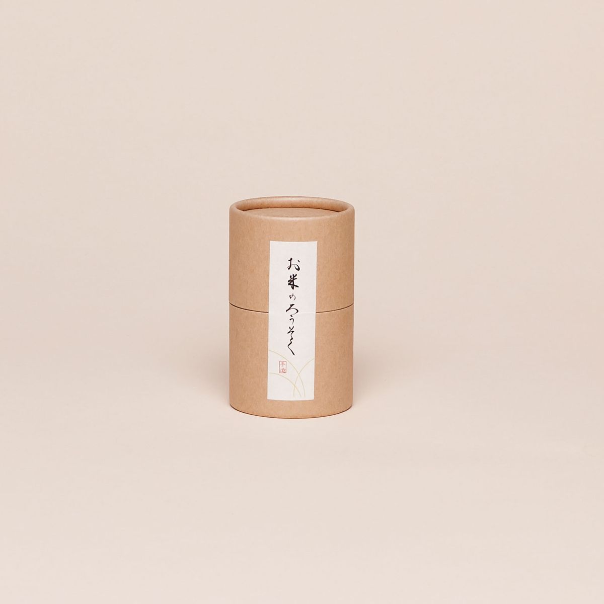 A brown cylindrical container with a white label with Japanese words