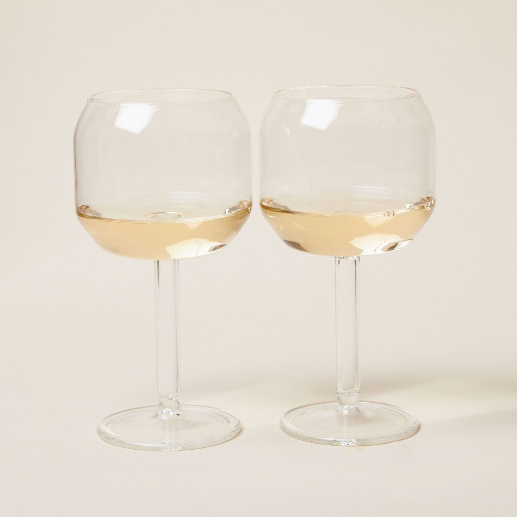 Two Velasca calices: stemmed wine glasses with large, tall bowls partly filled with white wine