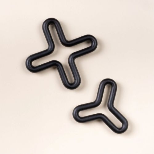 Two black wavy trivets shaped like a three-point and four-point star on a light neutral background.