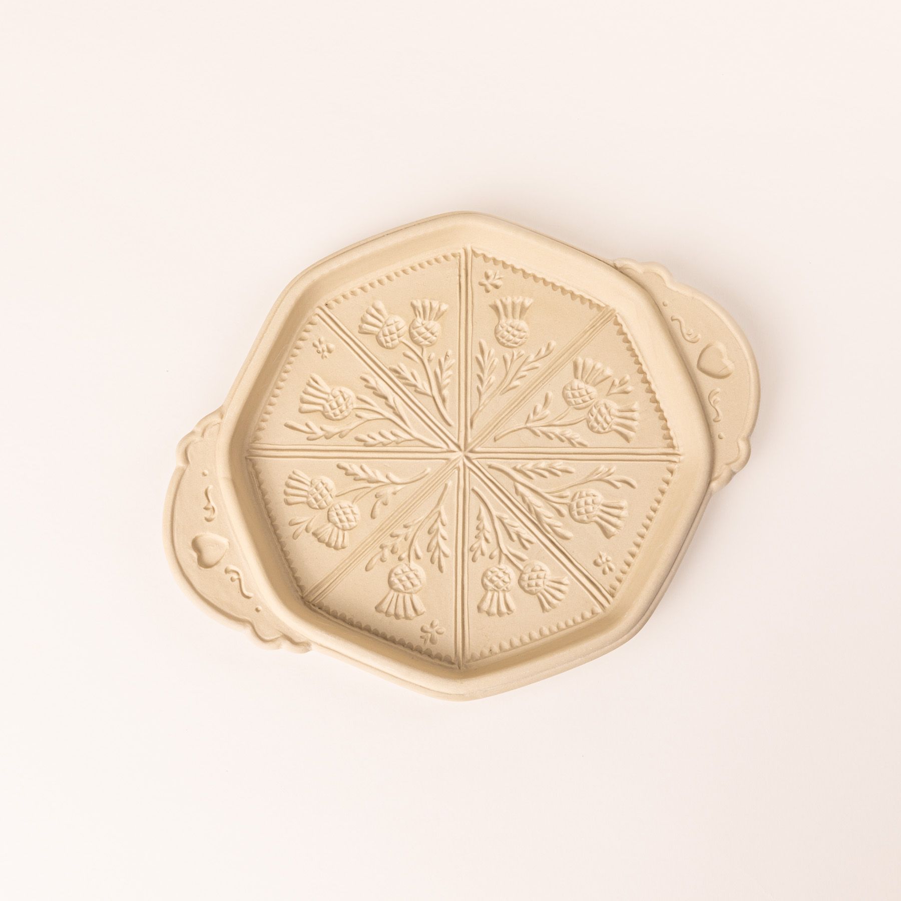 A shortbread pan with a thistle flower design on the bottom