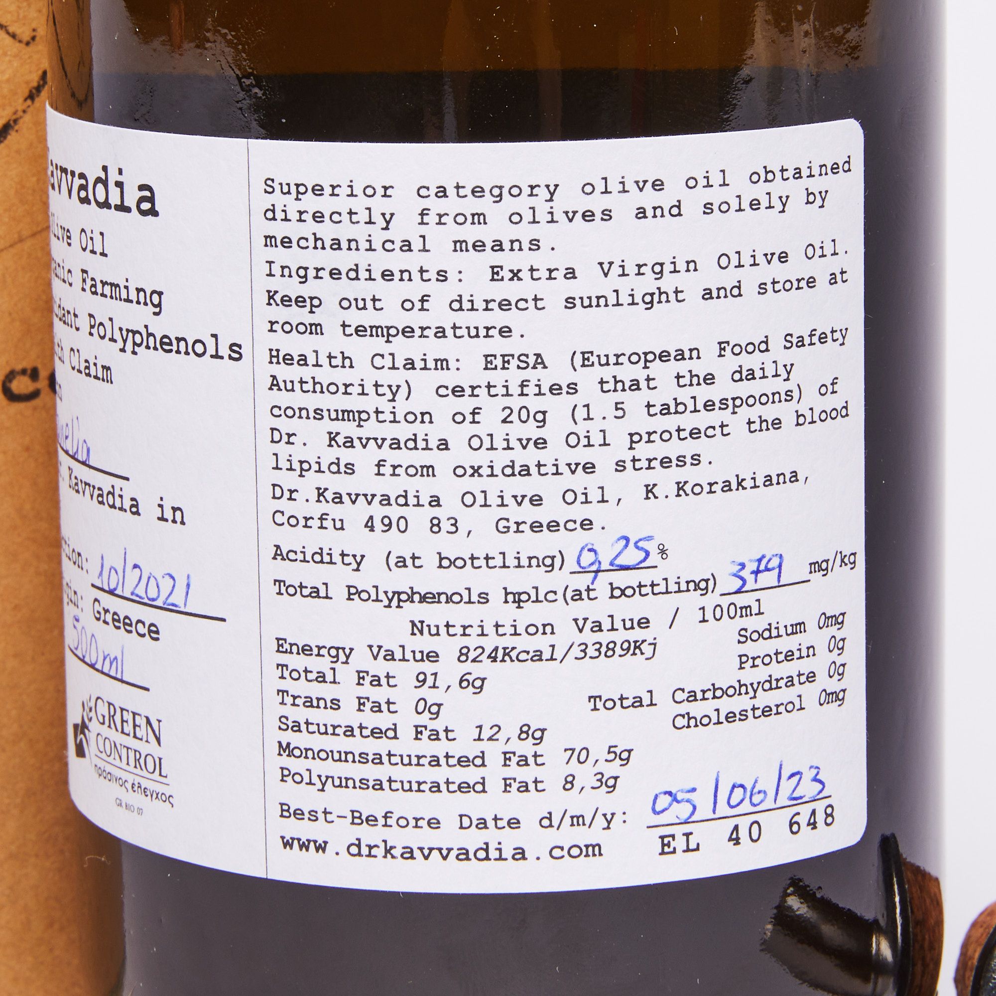 Close-up of a white label featuring nutritional facts on a dark bottle of olive oil