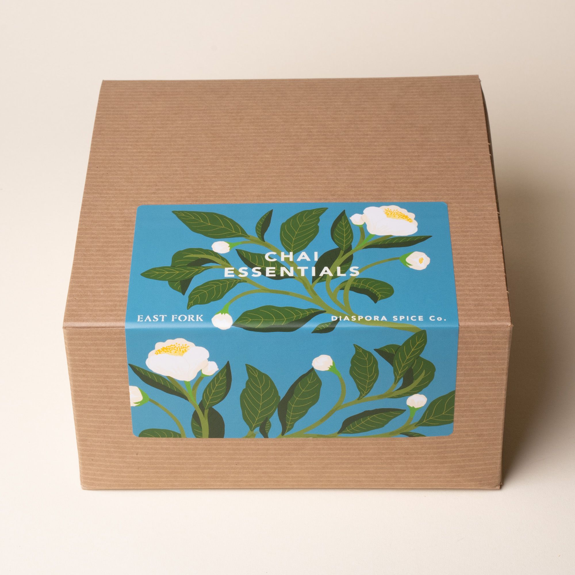 Brown gift box with a blue floral label reading “Chai Essentials” from East Fork and Diaspora Spice Co.