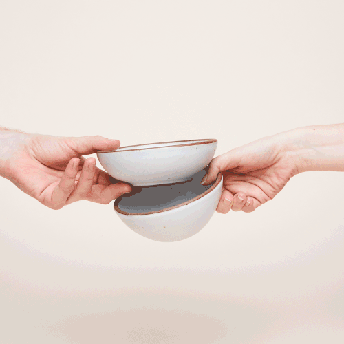 A moving image of two hands holding and spinning a breakfast bowl and ice cream bowl to compare.