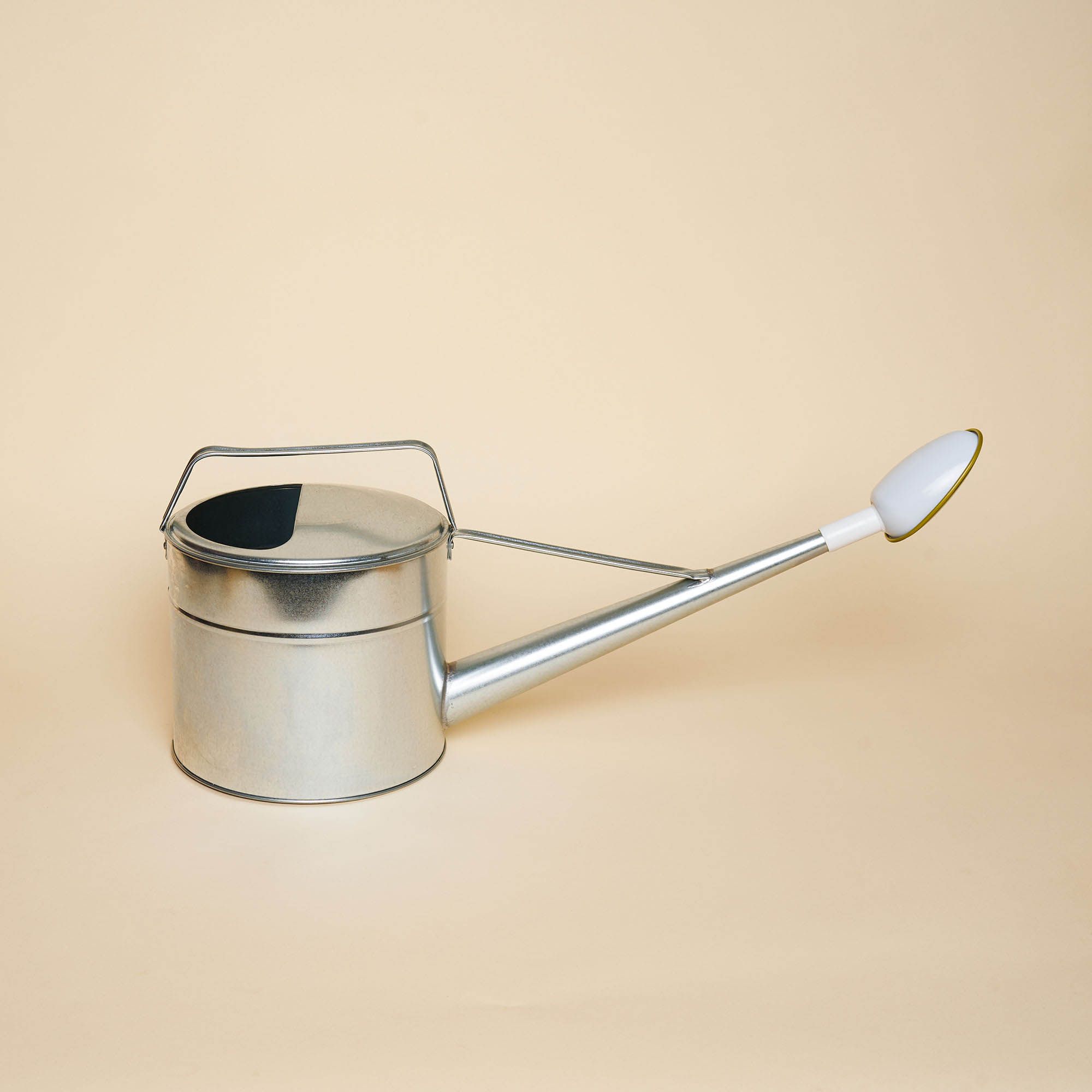 A iron-made watering can with a mustard colored nozzle.