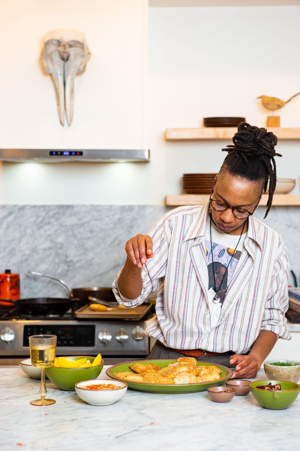 Ashleigh sprinkling spices on a plate of cod