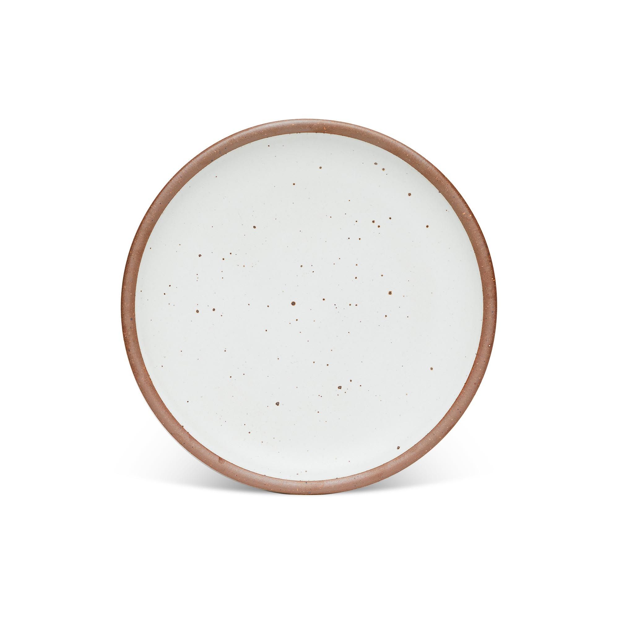 A dinner sized ceramic plate in a cool white color featuring iron speckles and an unglazed rim.