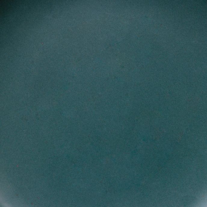 A closeup of a ceramic plate in a dark teal color