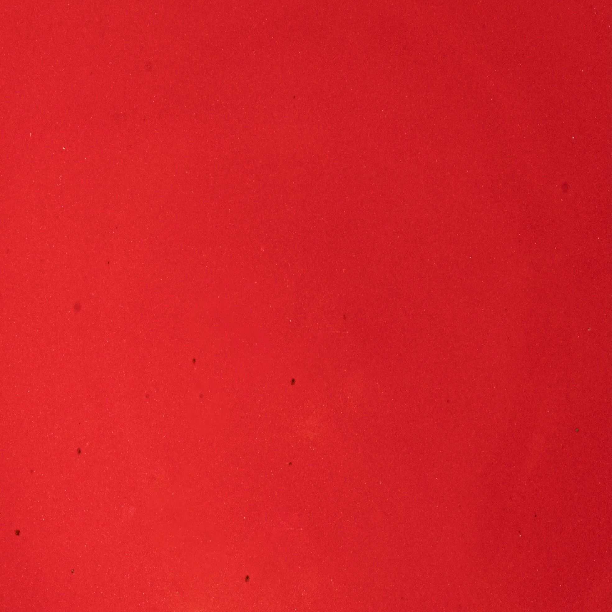 Closeup of a glossy red plate with subtle iron speckles