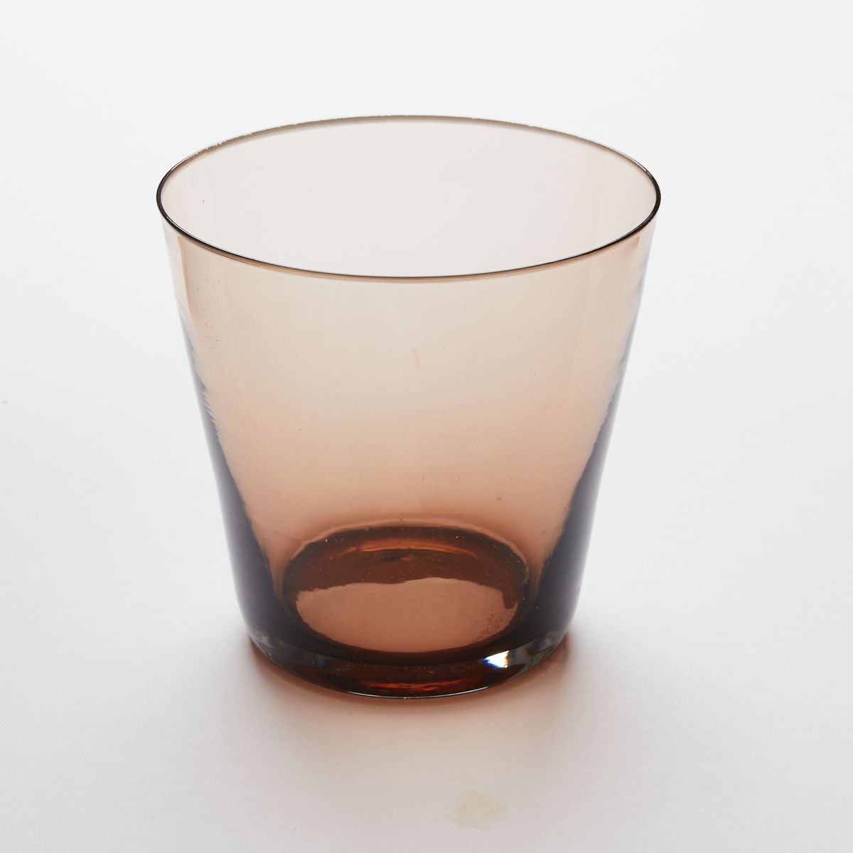 A short drinking glass made of walnut colored glass