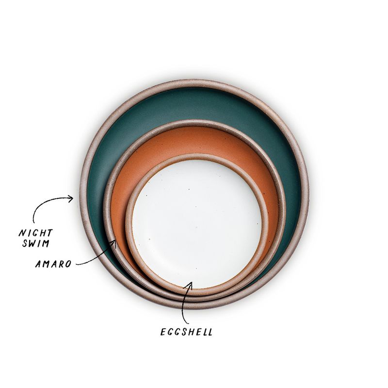 A stack of 3 plates in Dinner, Side, and Cake sizes in a dark teal, terracotta, and white colors.