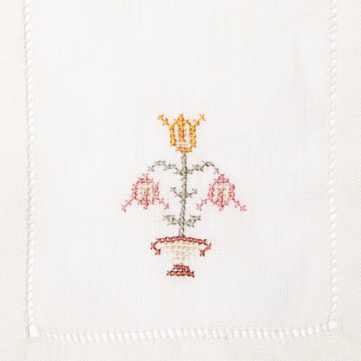Stack of cloth napkins with red embroidered flowers