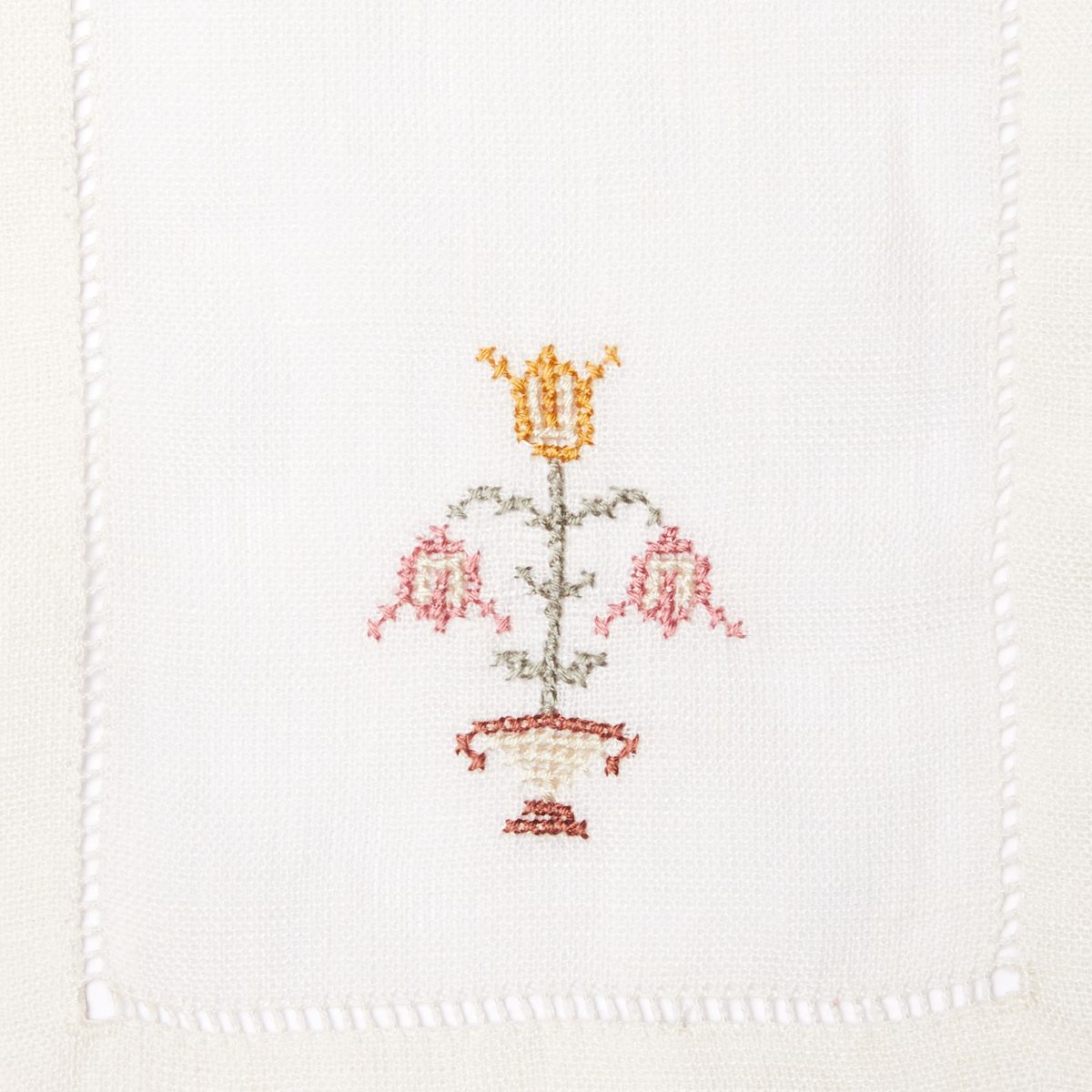 Stack of cloth napkins with red embroidered flowers