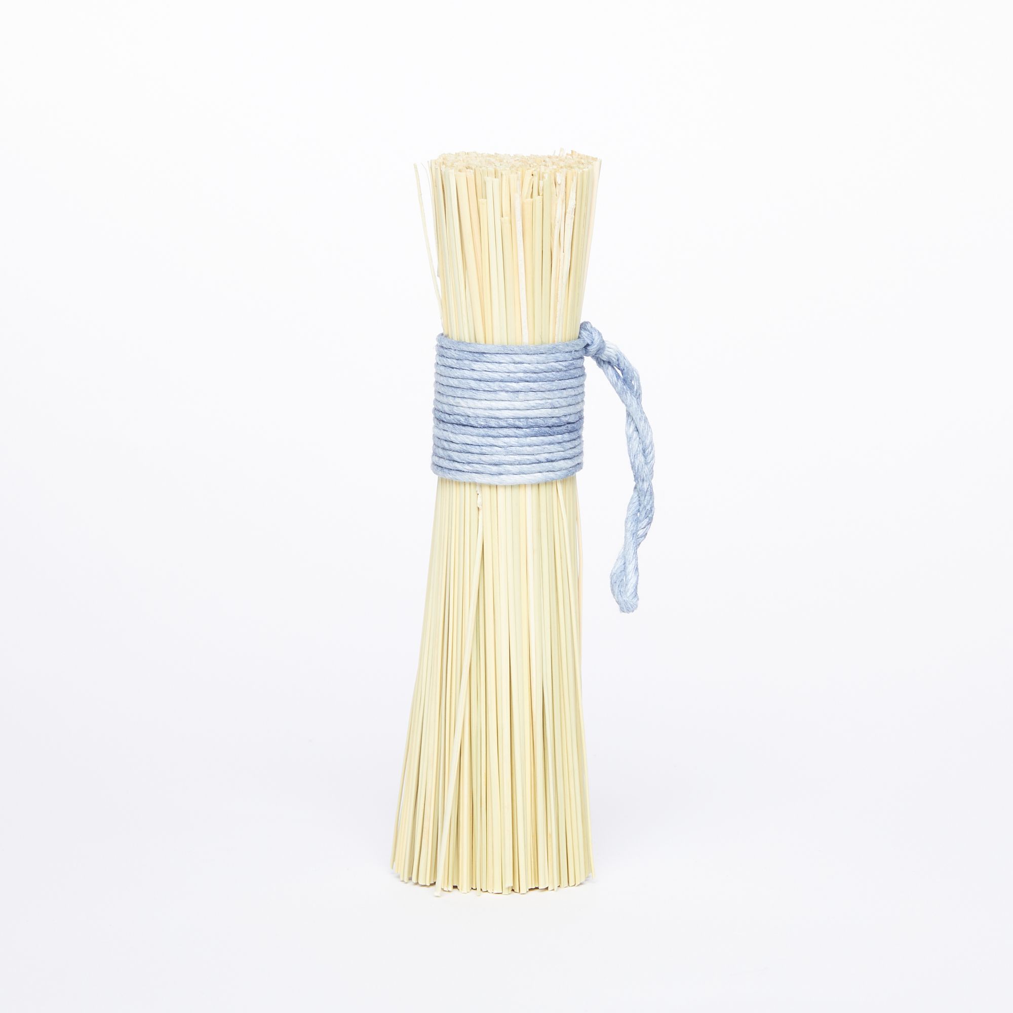 A pot scrubber made from a bundle of broomcorn tied at the handle with blue string