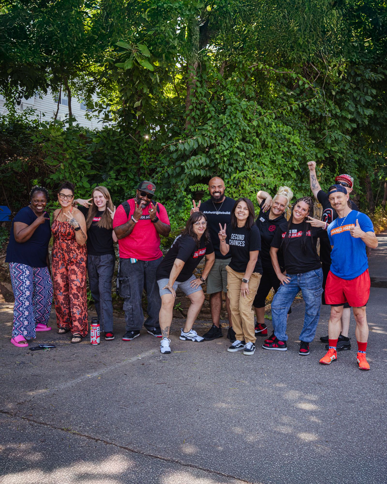 People from Operation Gateway are lined up and smiling sharing peace signs outside.