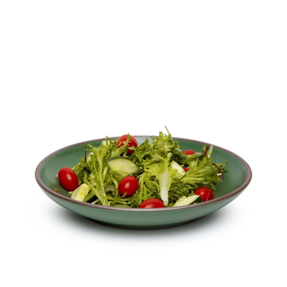 A large ceramic plate with a curved bowl edge in a deep, verdant green color featuring iron speckles and an unglazed rim, filled with salad.