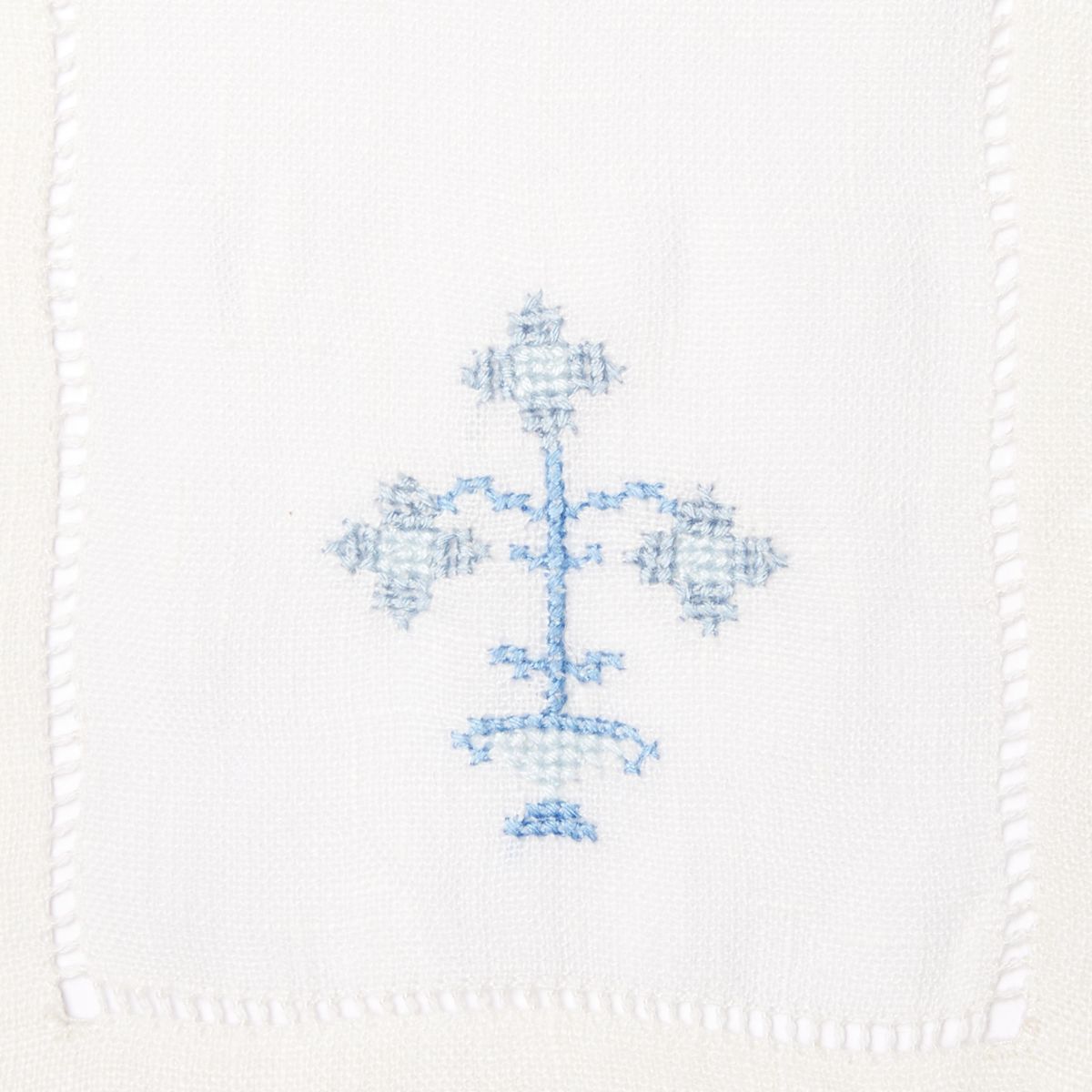 Stack of cloth napkins with blue embroidered flowers