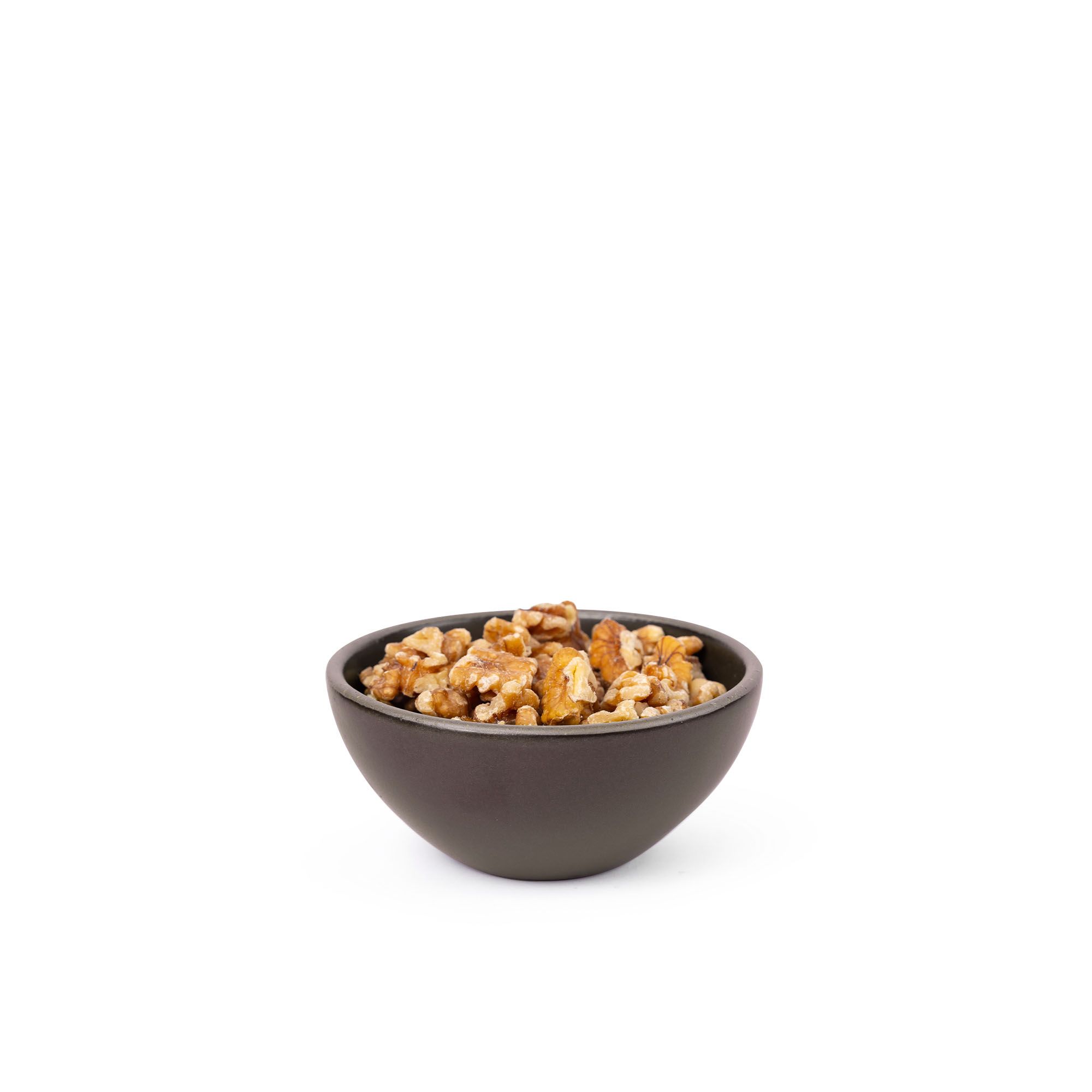 Walnuts in a small dessert sized rounded ceramic bowl in a dark cool brown color featuring iron speckles and an unglazed rim