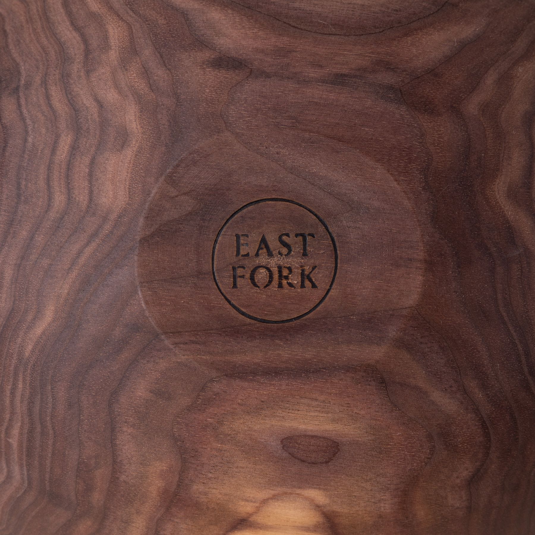 A close up of an East Fork stamp on the bottom of a walnut wood bowl