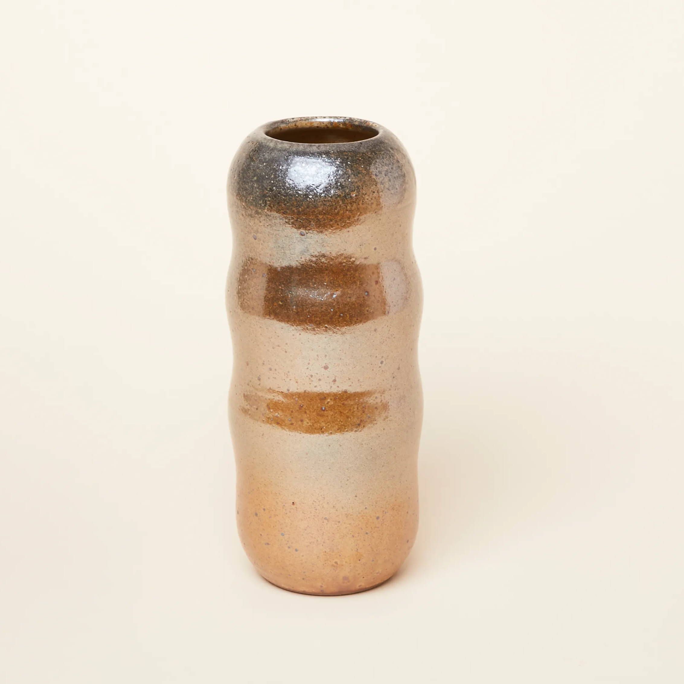 A tall curvy vase in a shiny and earthy glaze called "Shino"