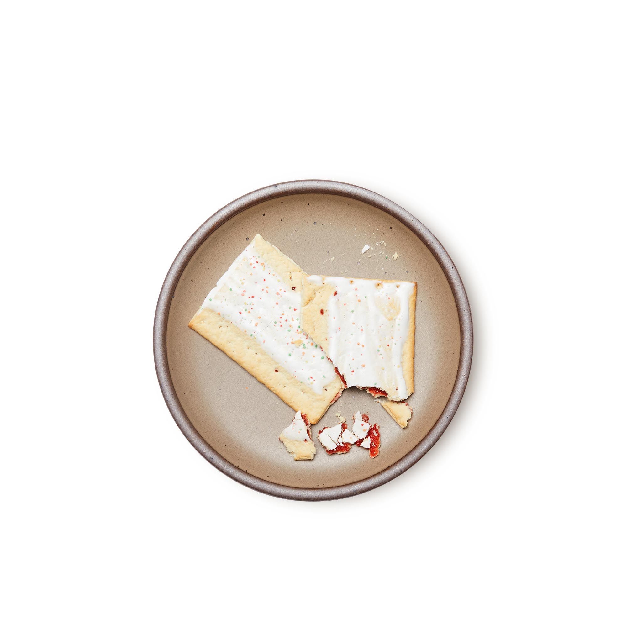 A poptart on a medium sized ceramic plate in a warm pale brown color featuring iron speckles and an unglazed rim.